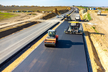 pavers paving on an split asphalt highway