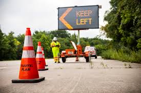 traffic cones and digital sign showing keep left