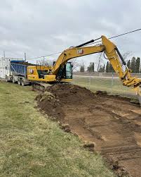 excavator stripping the top soil of land